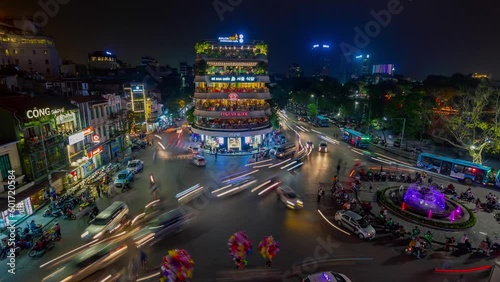 HANOI, VIETNAM - MAY, 2023: Night timelapse of Old Quarter, Traffic flow, cars and motobikes passing with light trails by night, old historical and residential buildings.