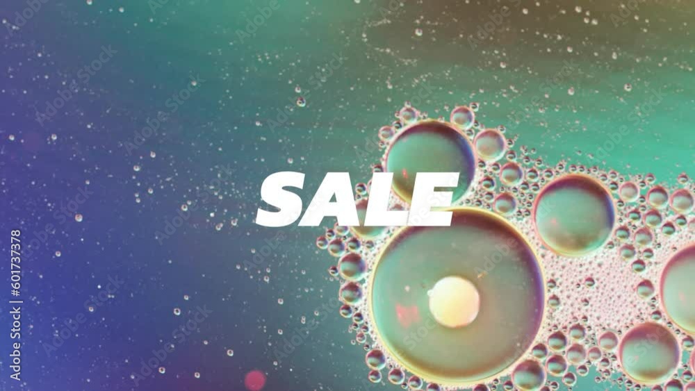 Animation of sale text over close up of liquid and baubles Animation of sale text over close up of liquid and baubles