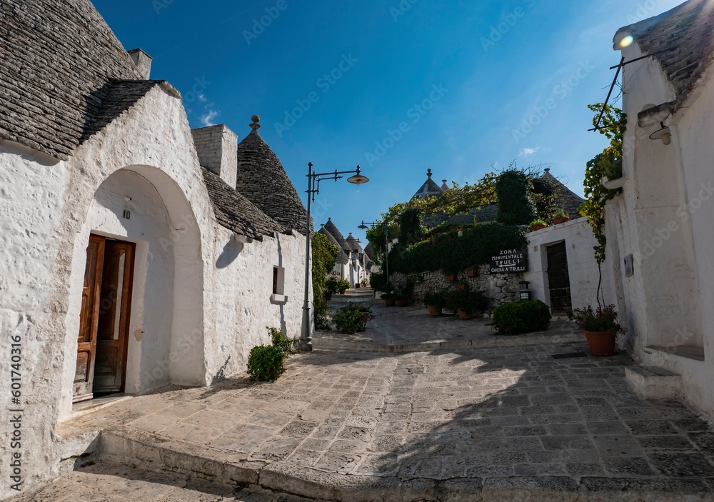 White Trulli houses in Alberobello, Italy in nice sunny afternoon with lens flare effect