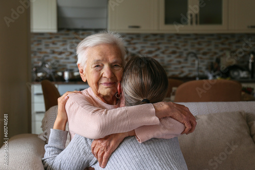 Grandmother and granddaughter hugging in the living room. Two adult women of different age. Family values concept. Close up, copy space, background.