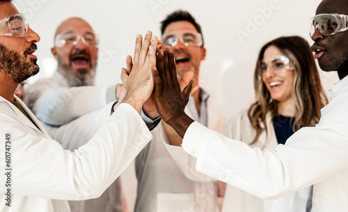  A diverse group of scientists from different ethnic backgrounds are gathered together, cheering and congratulating each other on a recent medical breakthrough.