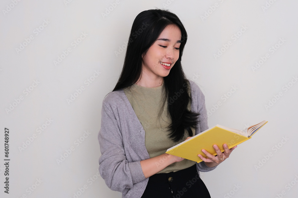 Young Asian woman smiling when reading a book Young Asian woman smiling when reading a book
