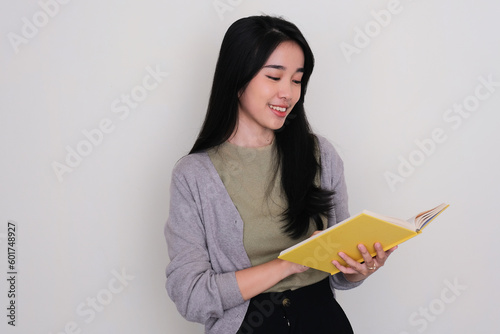 Young Asian woman smiling when reading a book photo