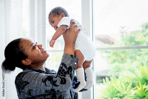 An African mother holding her son is 2-month-old baby newborn, with love and happy. concept to African family relationship and black baby newborn. photo