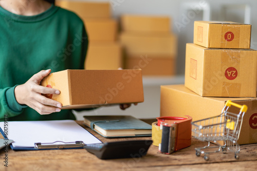 Small business entrepreneurs, SMEs, freelancers, working with boxes at home, using laptops for commercial inspection. Online Marketing SME Packaging Box Shipping Concept