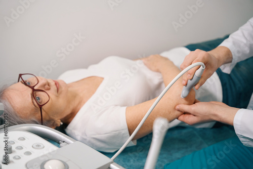 Pensioner in glasses on a joint examination on ultrasound machine