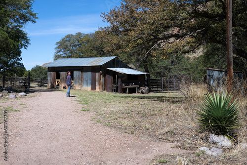 A woman walking near an old Arizona barn