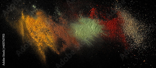 Fototapeta Naklejka Na Ścianę i Meble -  Various spice explosion, turmeric, cinnamon powder, ground lemongrass, cayenne pepper and caribbean mix spice isolated on black background