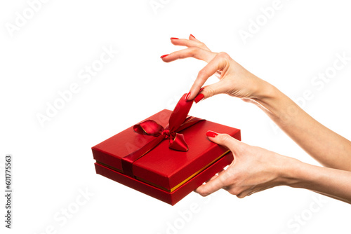 Woman giving a christmas or birthday gift wrapped in red paper and red ribbon on white background.