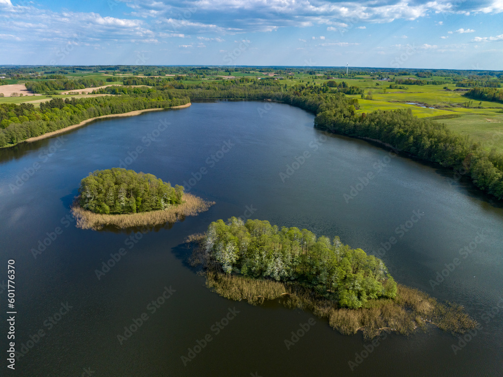 Beautiful drone nature landscape of fields, meadows, forest and lake - sunny day in Poland, Mazury aerial view