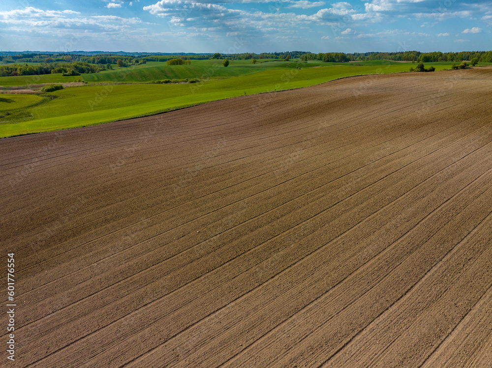Aerial view of plowed agricultural field in spring with blue sky, Poland, Mazury Aerial view of plowed agricultural field in spring with blue sky, Poland, Mazury
