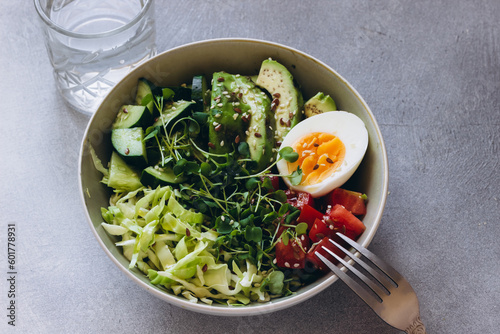 Summer green healthy bowl salad with avocado, arugula microgreens, cucumber, cabbage and tomatoes,eggs