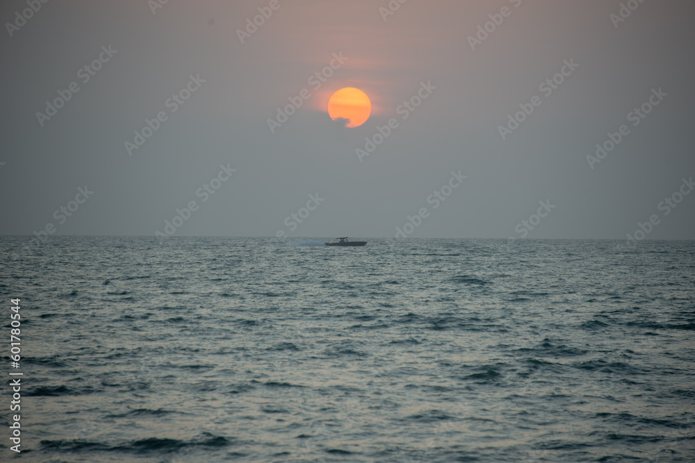 orange sunset over the see with a little fog and dramatic sun orange sunset over the see with a little fog and dramatic sun