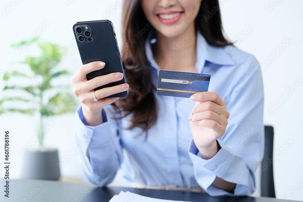 Young smiling Asian woman using tablet buying online shopping by credit card while lying on sofa when relax in living room at home. Lifestyle latin and hispanic ethnicity women at house concept. Young smiling Asian woman using tablet buying online shopping by credit card while lying on sofa when relax in living room at home. Lifestyle latin and hispanic ethnicity women at house concept.