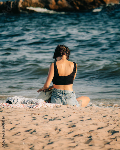 Woman sitting on sand at the beach