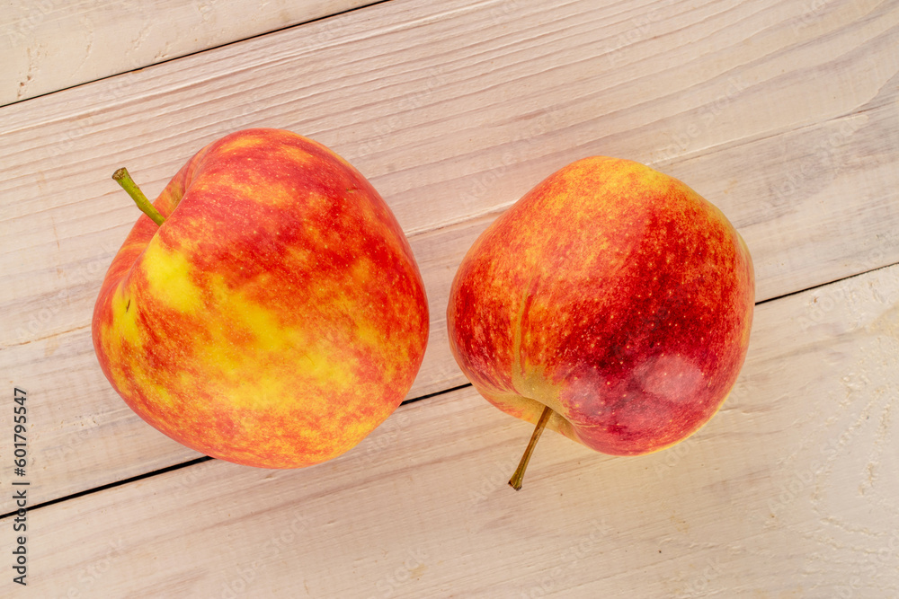Two organic red apples on a wooden table, macro, top view. Two organic red apples on a wooden table, macro, top view.