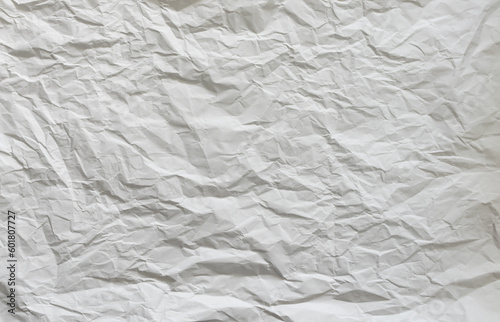 Wrinkled white paper background. Empty crumpled material with a random structure. Abstract and wavy pattern as creative backdrop.