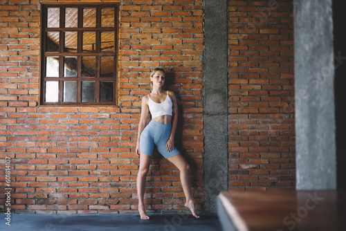 Slim woman model standing near brick wall