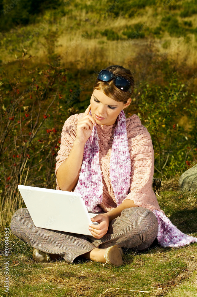 Young business woman relaxing, working on laptop computer on meadow Young business woman relaxing, working on laptop computer on meadow
