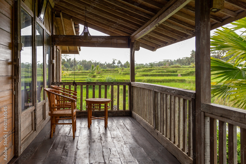 A small terrace in a wooden house, surrounded by rice fields, Ubud, Bali A small terrace in a wooden house, surrounded by rice fields, Ubud, Bali