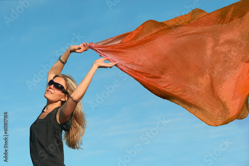 Принти на полотні Beautiful blond woman running with a orange scarf