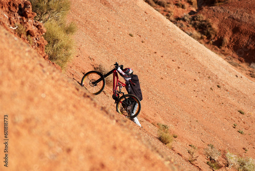Extreme biker uphill in red canyon