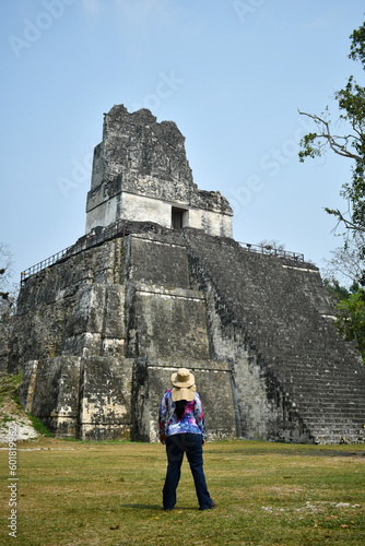 Mujer Viajera viendo hacia el Templo de las Mascaras. Templo II en la Plaza Central. Tikal, Guatemala. photo