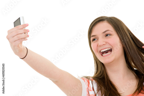 Caucasian teenager using a cell to take a pictue of herself on white background photo