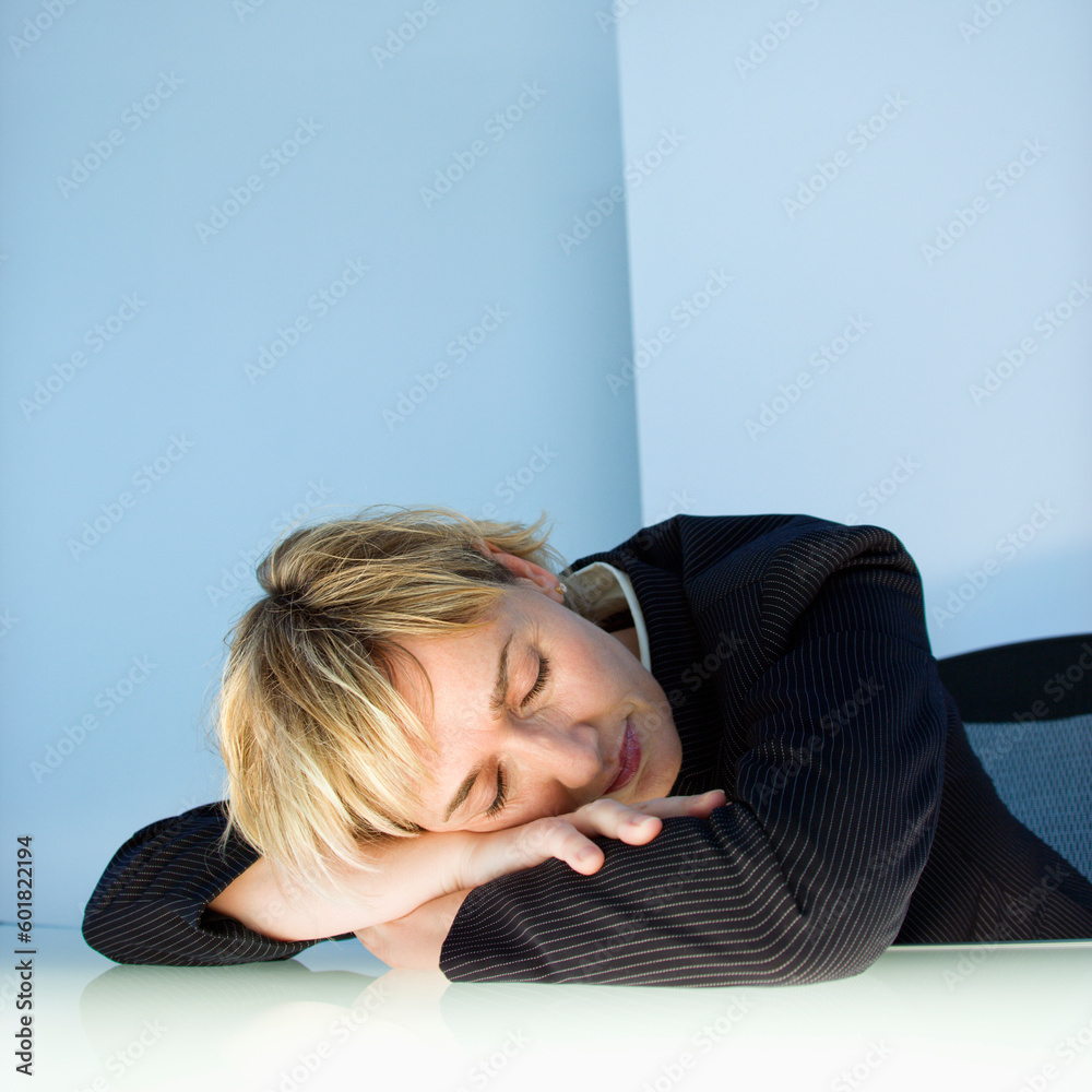 Caucasian businesswoman sleeping with head on desk in work office. Caucasian businesswoman sleeping with head on desk in work office.