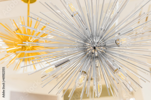 Close-up of a switched off incandescent lamp in a ceiling with a clear glass chandelier in the form of a modern style tube. Indoors.