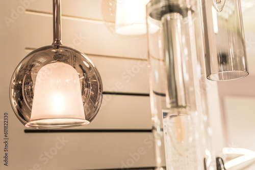 Round glass LED ceiling-mounted chandelier with a decorative element in the shape of a bell inside in the interior