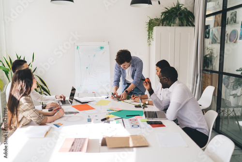 Group of diverse colleagues working on project in meeting room in office