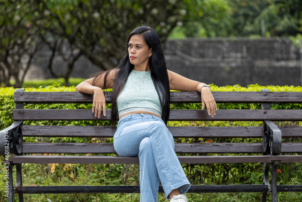 Naklejka premium asian girl sitting in a bench with a very long hair
