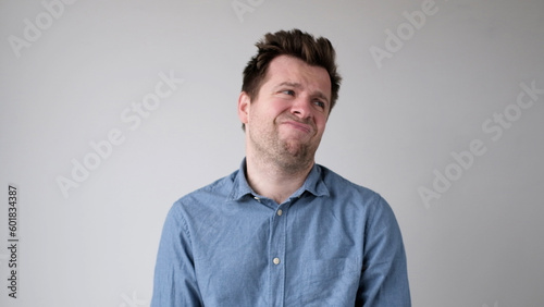 European young man is hesitating and unwilling to make decisions. He is upset about having to do unpleasant work.
