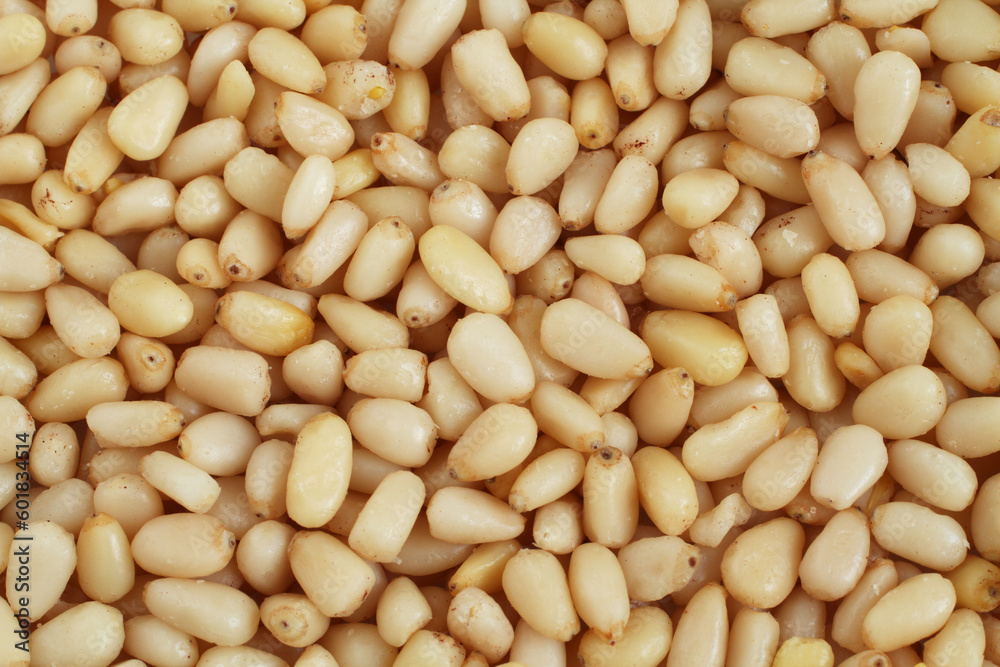 A pile of raw shelled pine nuts arranged randomly. View from above. Closeup