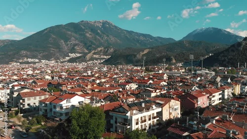 Fly zoom in the city center in the middle of the green countryside in fethie, turkey, in summer, on a sunny day. High quality 4k footage photo