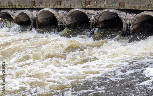 Environmental pollution, environmental disaster. Discharge of polluted sewage into the river from factory concrete pipes. Hazardous waste water. Environmental protection. Water pollution.
