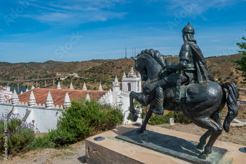 Equestrian statue of Ibn Qasi. Senhor of Mértola with Church of Our Lady of Annunciation and Guadiana River, Mértola PORTUGAL