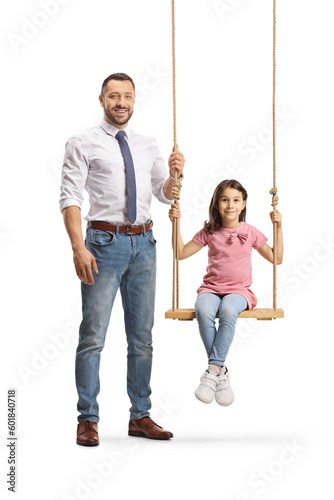 Full length portrait of a father standing nexto to a girl on a swing