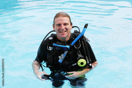 Happy scuba diver in the swimming pool.