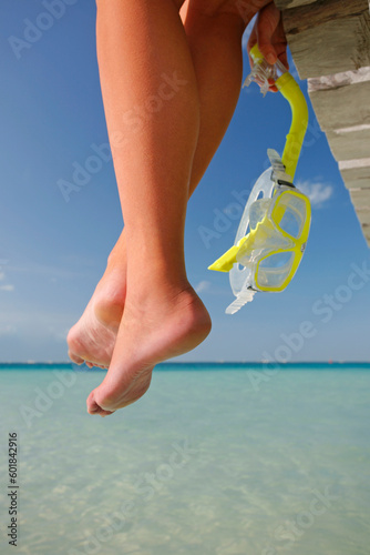 One of a large series. Great set of legs hanging over the edge of a tropical jetty with a diving mask.