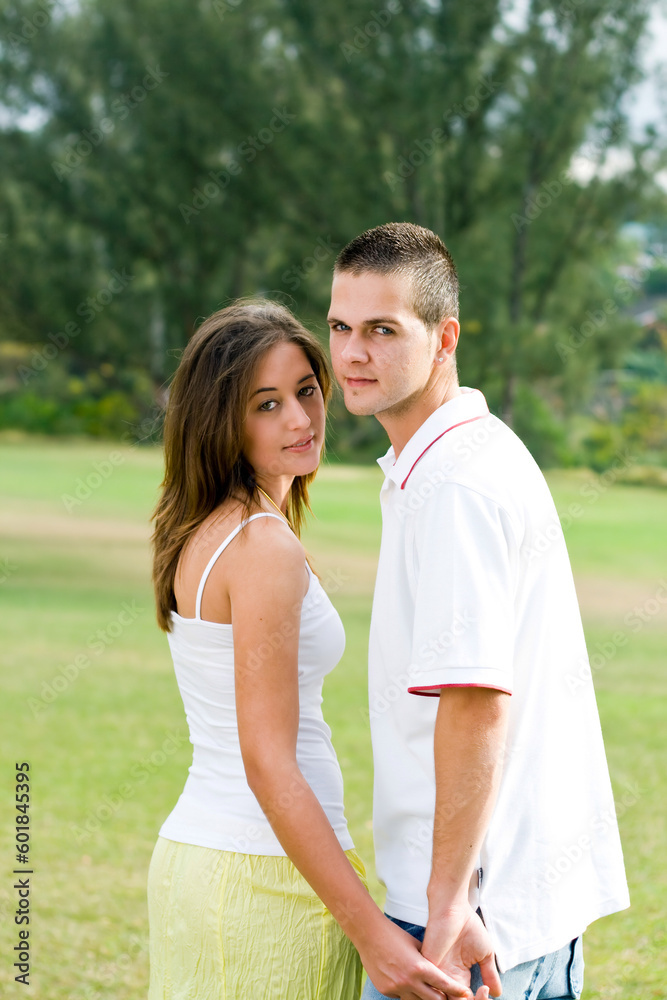 beautiful young couple holding hands outdoors