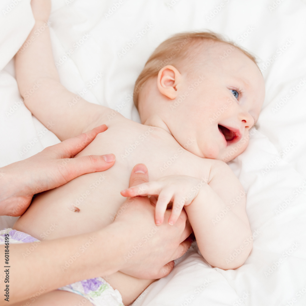 Mother massaging her child, shallow focus Mother massaging her child, shallow focus