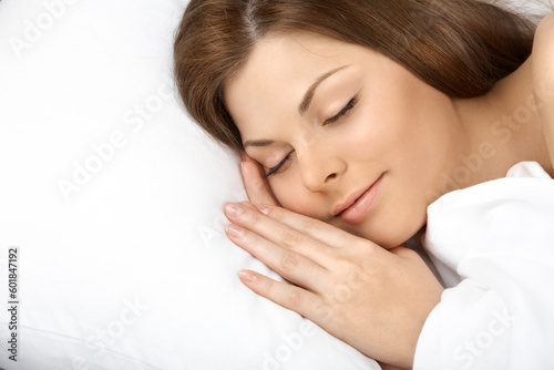 Portrait of the beautiful sleeping woman in white bed