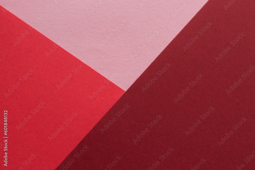 Paper in three shades of red lies on the table, creating a geometric composition Paper in three shades of red lies on the table, creating a geometric composition