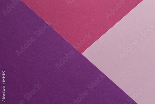Pink, burgundy and purple paper lie on the table in a geometric composition