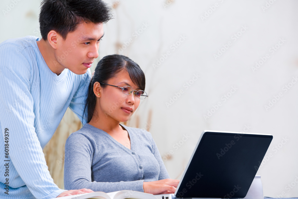 Young Asian couple using laptop at home. Young Asian couple using laptop at home.