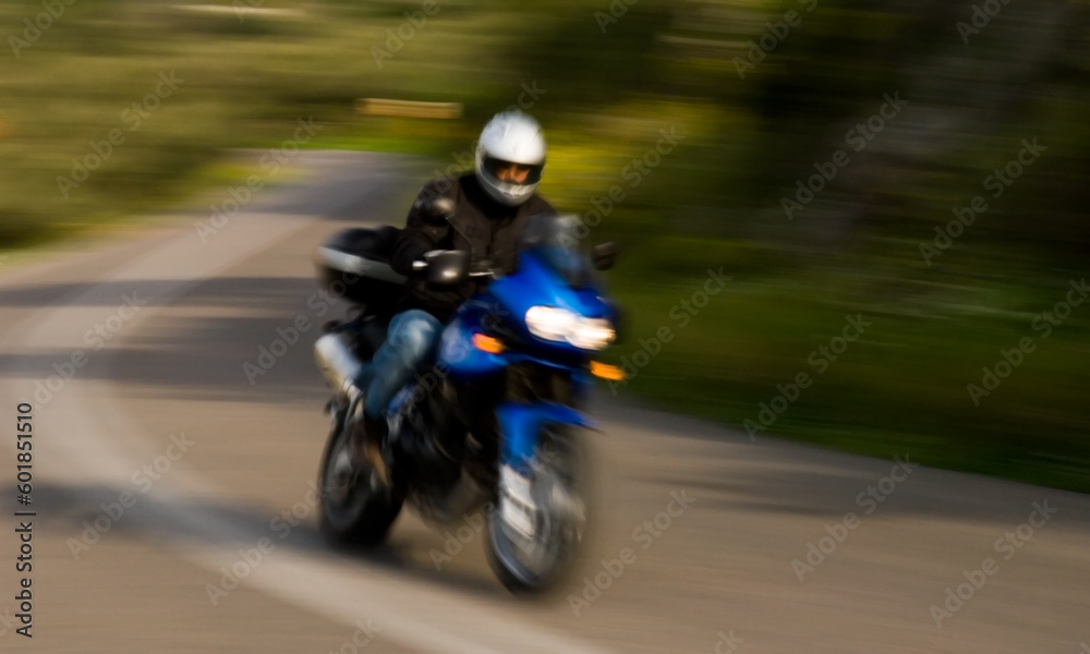 A motorcycle rider captured negotiating an S-curve at high speed