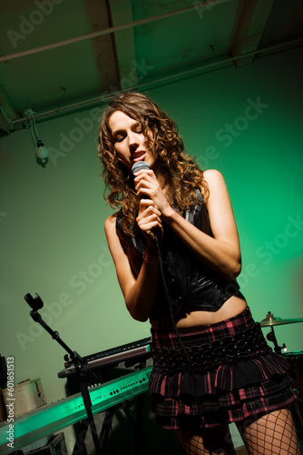 Caucasian female singning into microphone. photo