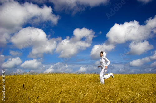 Beautiful woman running on a golden meadow